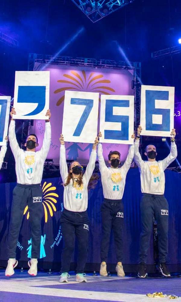 Students on stage displaying 13.7 million dollars raised for Thon.