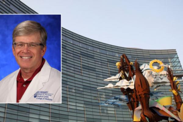 A head and shoulders professional portrait of Kent Hymel against a background image of Penn State Health Children's Hospital.