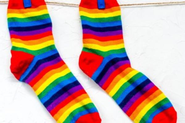 挂在晾衣绳上的一双彩虹色袜子的特写镜头。