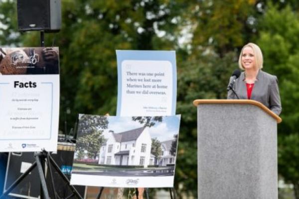 Jennifer Kraschnewski博士站在领奖台上发表演讲，这是作为“让你的6个家在家”倡议的一部分而建造的第一个家的奠基仪式。