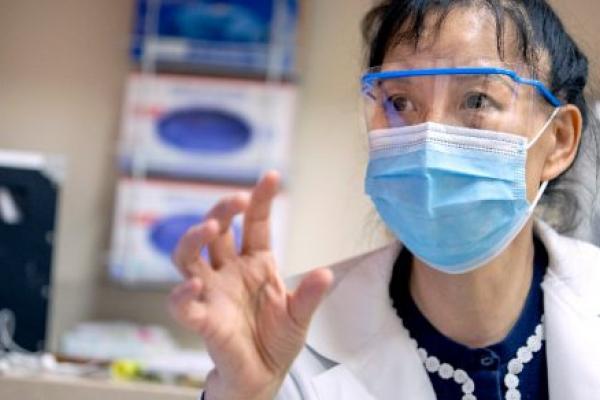 Dr. Xuemei Huang has a discussion with a patient.